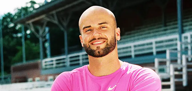 Speerwerfer Julian Weber im rosa Trikot, mit weißer Kappe hält den Speer vor seinem Gesicht bereit zum Abwurf (Foto)